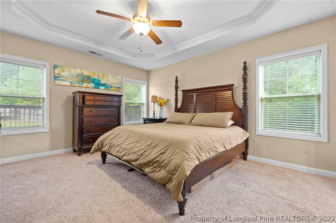 60 Shellbark Drive Spring Lake, NC 28390 - Photo 19 of 42 a spacious bedroom with a large bed and a chandelier