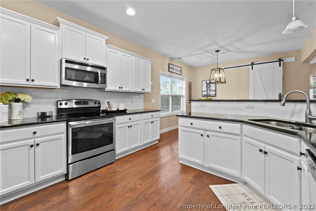 60 Shellbark Drive Spring Lake, NC 28390 - Photo 10 of 42 a kitchen with stainless steel appliances granite countertop a stove a sink and a microwave