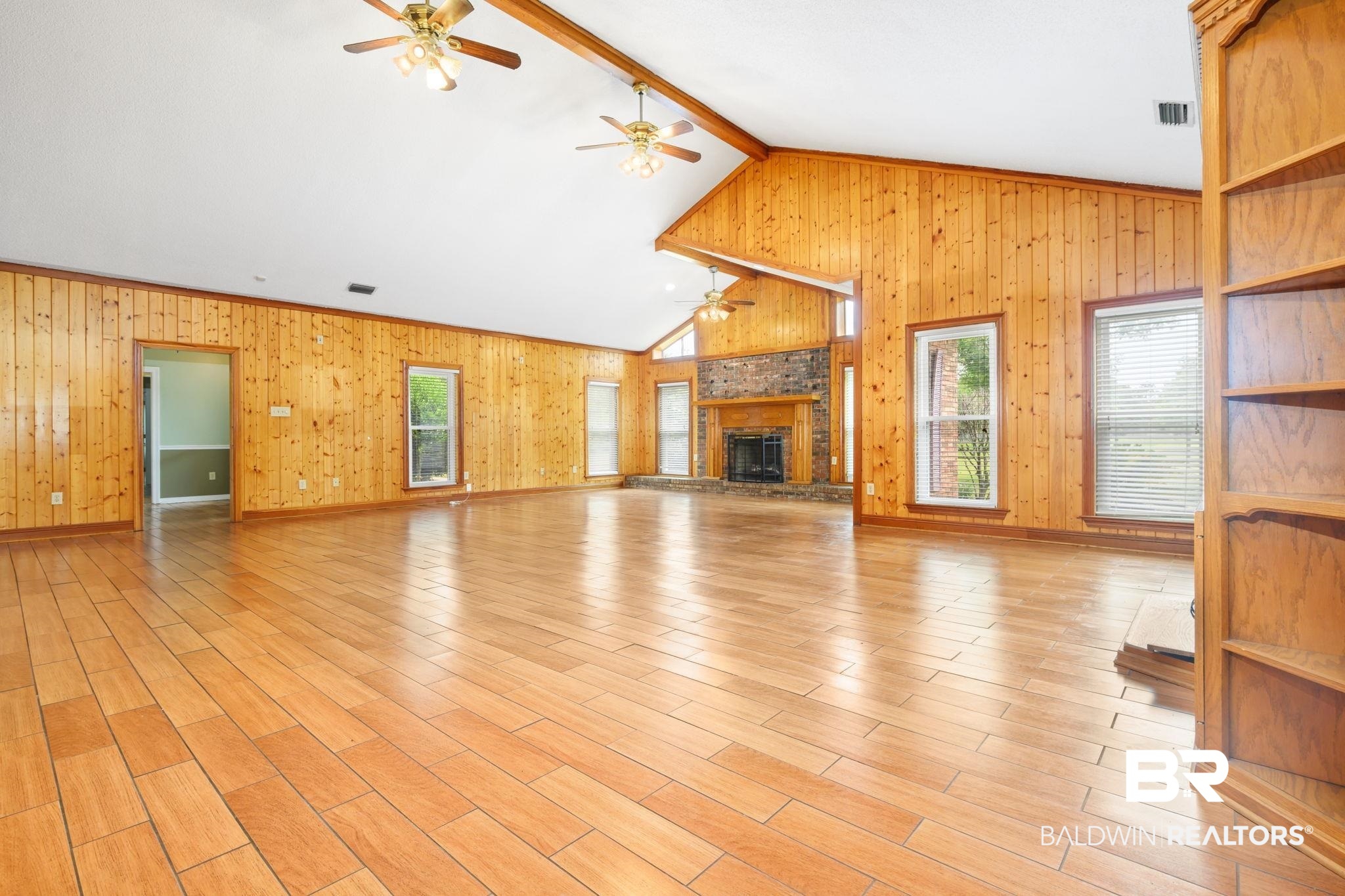7540 2 Mile Road Irvington, AL 36544 - Photo 18 of 82 Spacious open-concept interior featuring light wood-finish flooring and extensive wood paneling