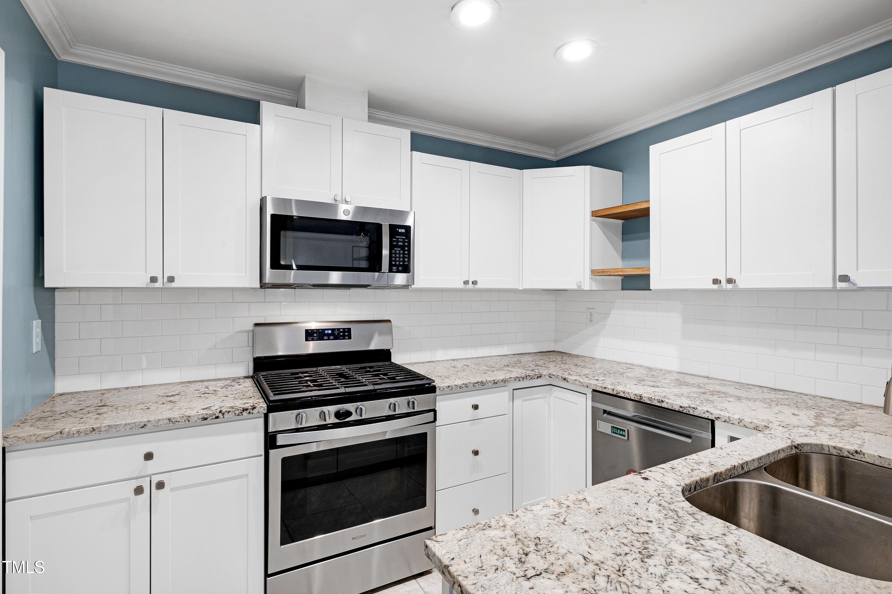 119 Joanne Circle Cary, NC 27513 - Photo 1 of 42 a kitchen with granite countertop white cabinets sink and stainless steel appliances