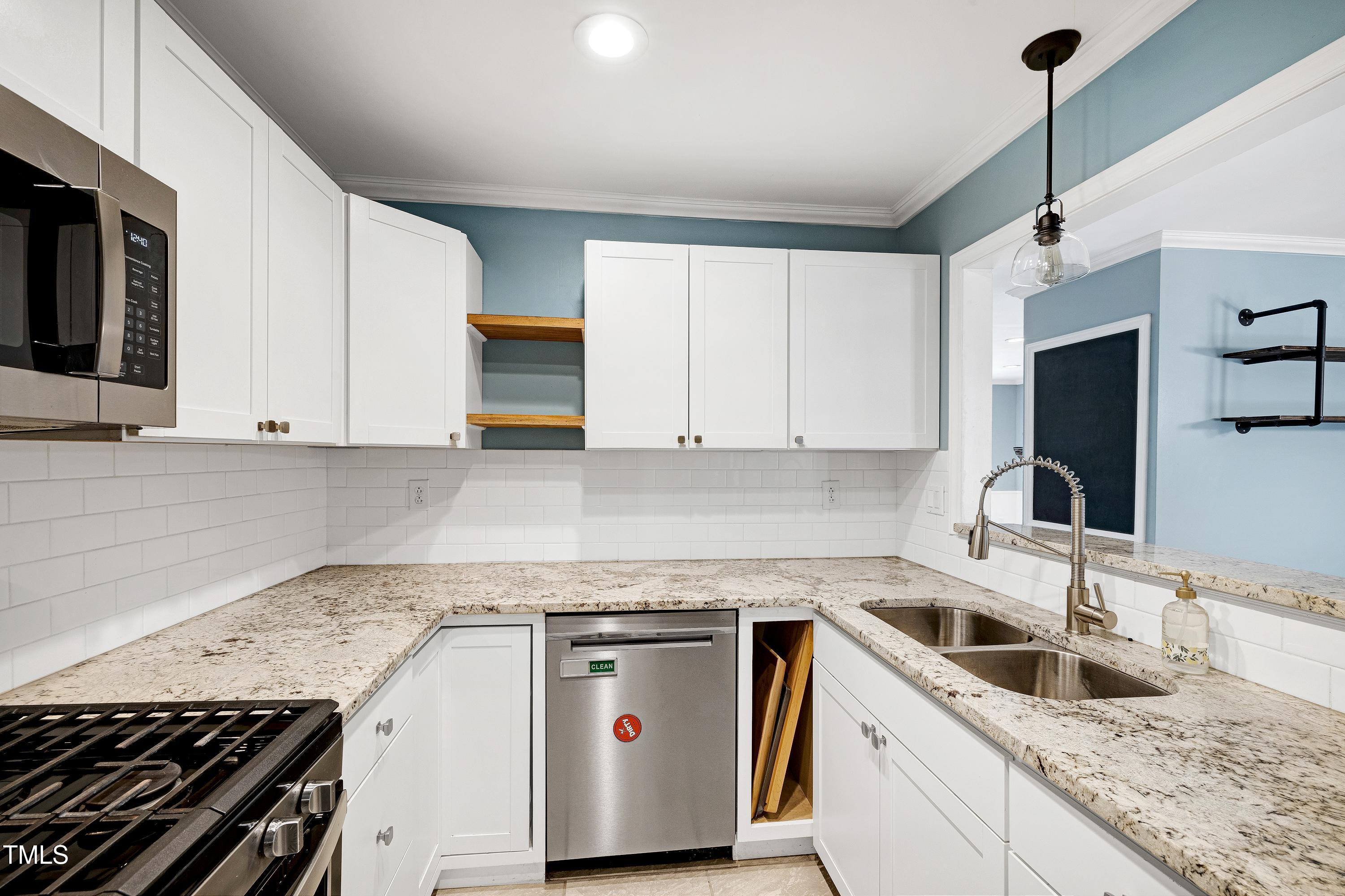 119 Joanne Circle Cary, NC 27513 - Photo 15 of 42 a kitchen with granite countertop a sink a stove and cabinets