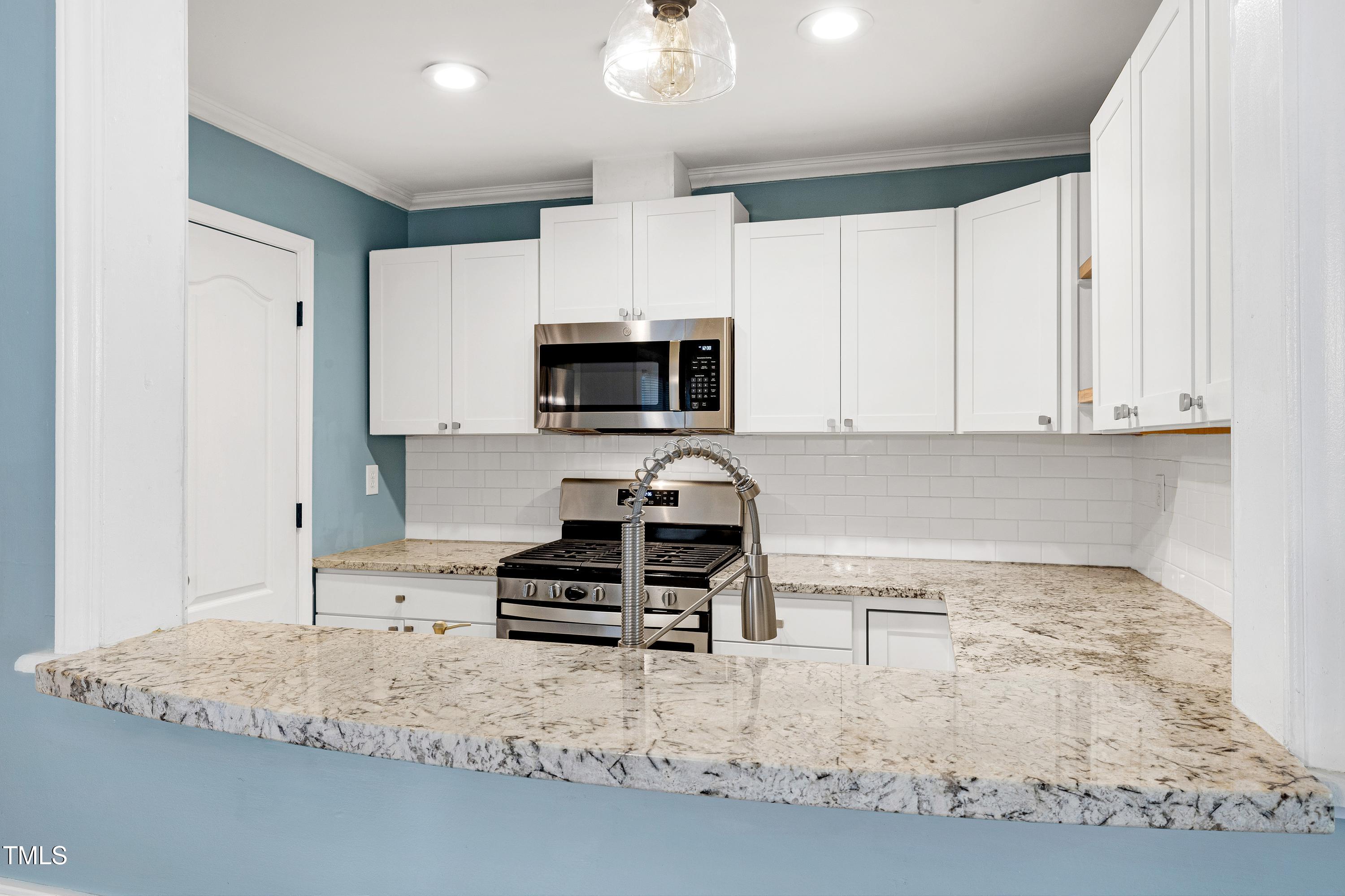 119 Joanne Circle Cary, NC 27513 - Photo 3 of 42 a kitchen with granite countertop a stove sink and cabinets