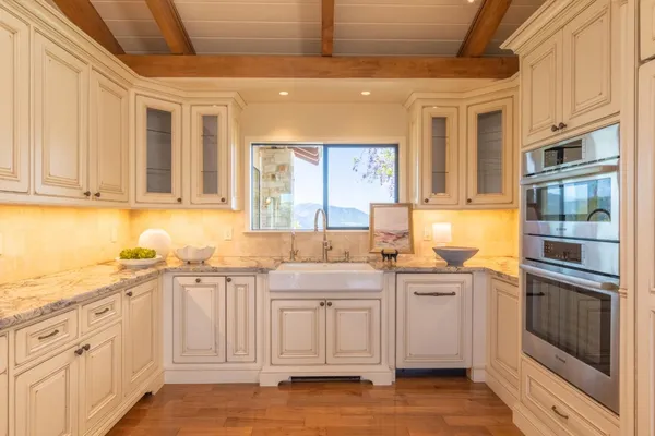 a kitchen with stainless steel appliances granite countertop a sink and cabinets with wooden floors