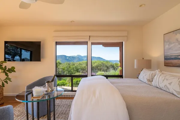 a view of a bedroom with furniture and balcony