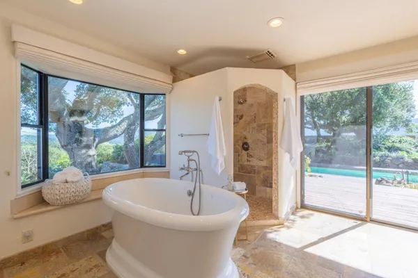 a spacious bathroom with a bathtub and large window