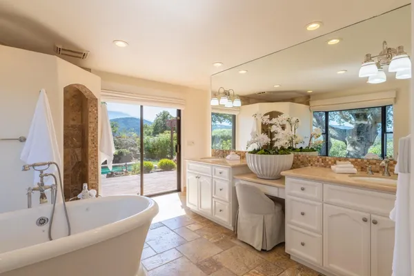 a bathroom with a tub sink and mirror