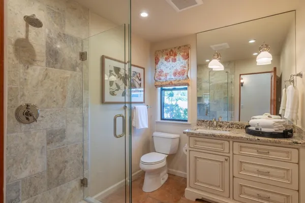 a bathroom with a granite countertop sink toilet and shower