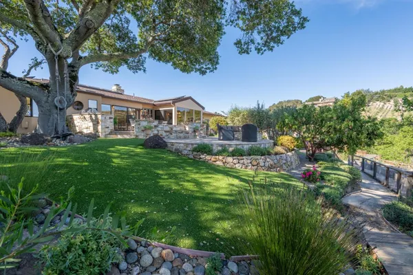 a view of house with a big yard and large trees