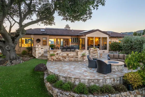 a front view of a house with garden and sitting area