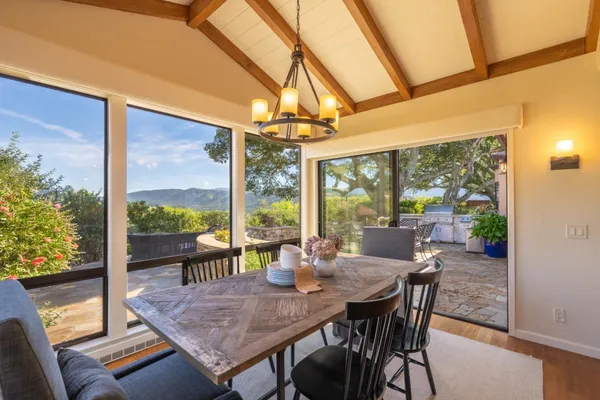 a view of a dining room with furniture large windows and wooden floor