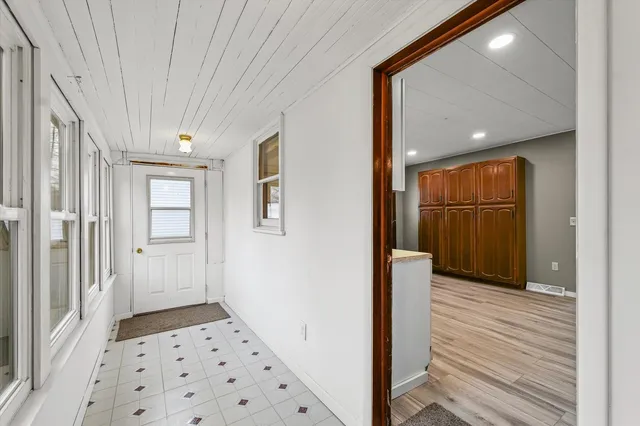 a view of a hallway with wooden floor and cabinet