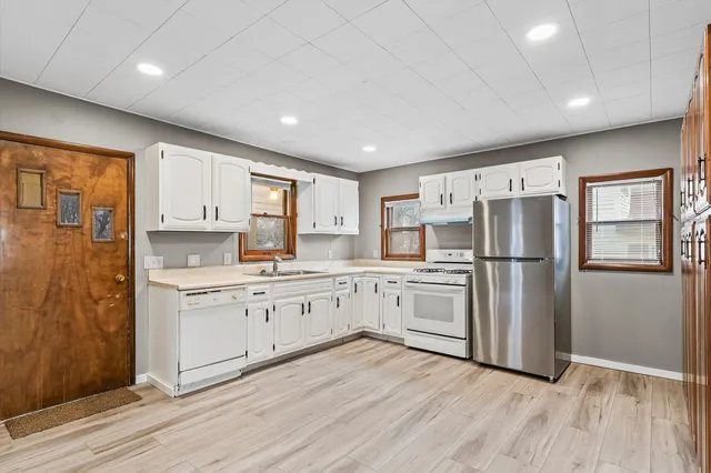 a kitchen with refrigerator cabinets and wooden floor