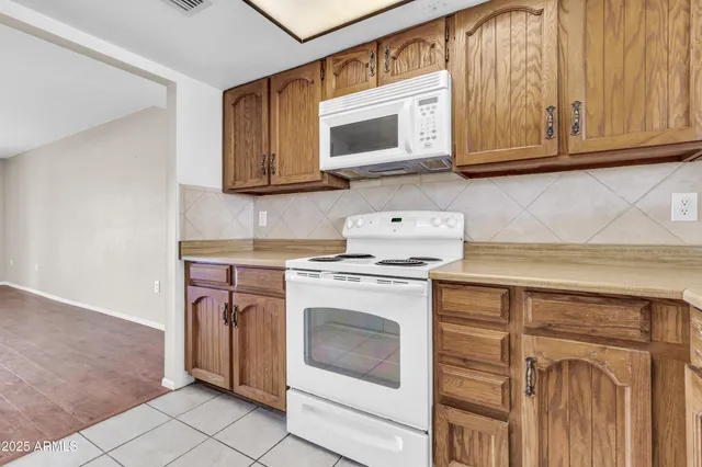 a kitchen with white cabinets and sink
