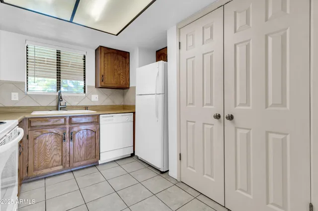 a kitchen with stainless steel appliances granite countertop a sink and dishwasher a stove top oven with white cabinets