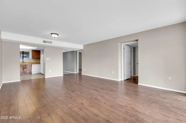 a view of empty room with wooden floor