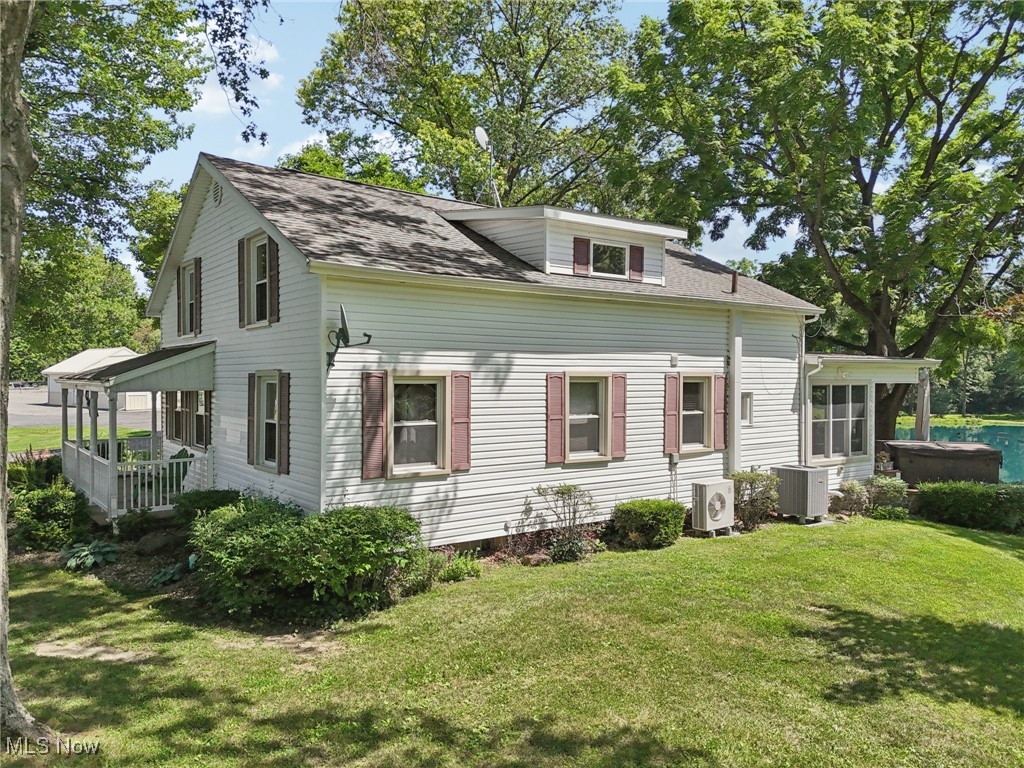 6414 Tennant Road Collins, OH 44826 - Photo 34 of 50 View of front facade featuring a shingled roof, a front yard, and a sunroom