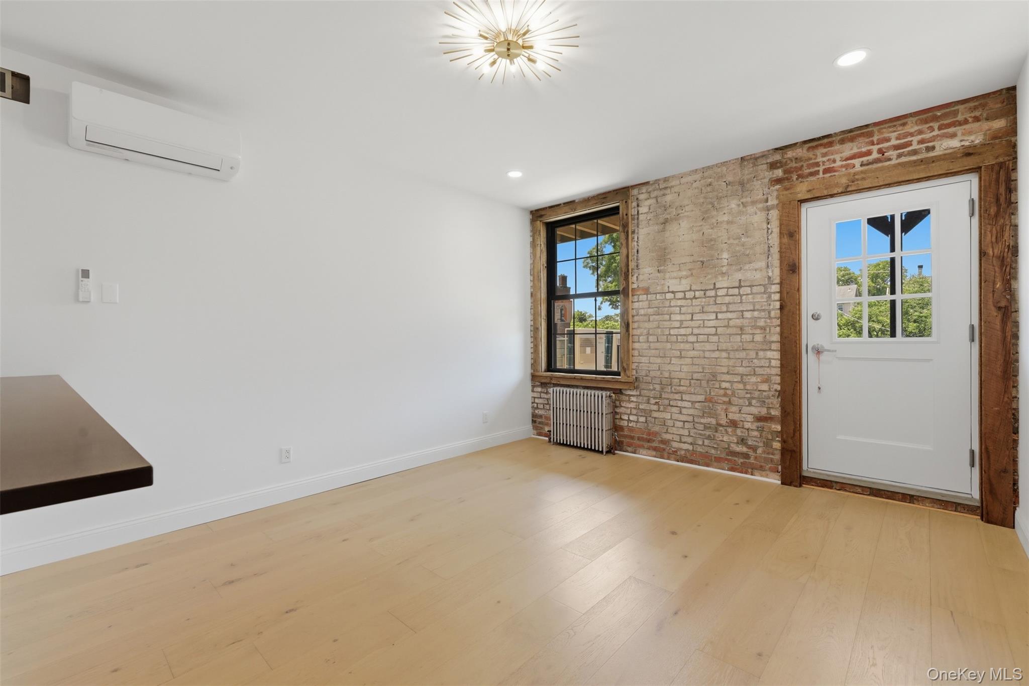 207 Main Street, Unit 5 Beacon, NY 12508 - Photo 11 of 20 an empty room with chandelier fan and windows