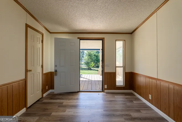 an empty room with wooden floor and windows