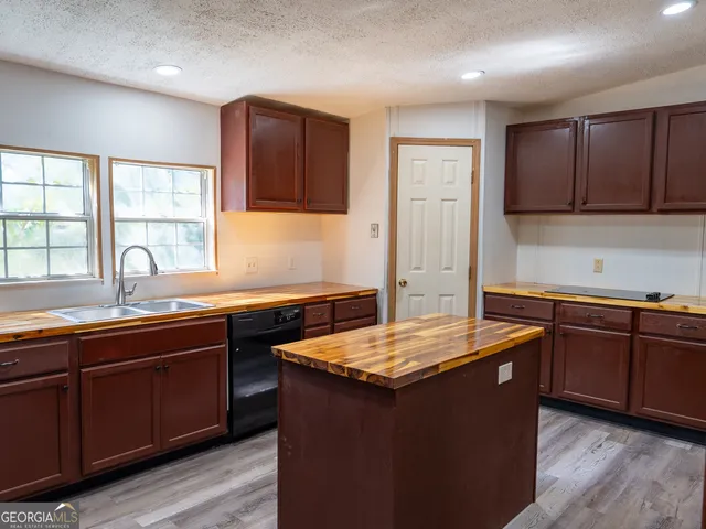 a kitchen with granite countertop a sink stove and cabinets
