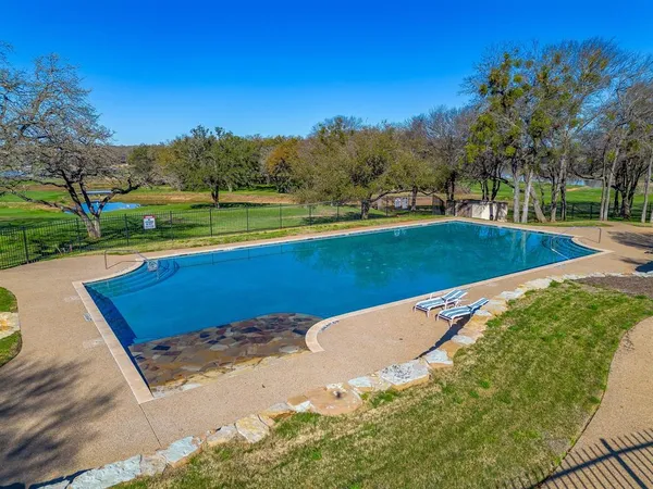 a view of a swimming pool and trees in the background