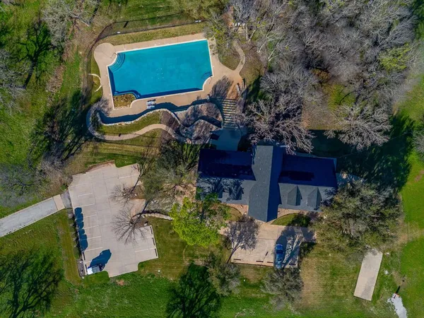 an aerial view of a house with a garden and trees