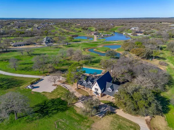 an aerial view of residential houses with outdoor space and trees