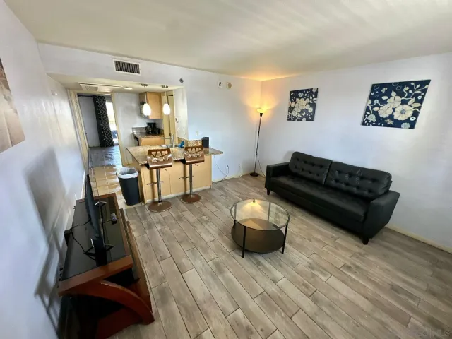 a living room with furniture and a wooden floor