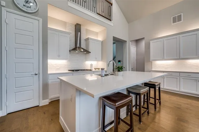 a kitchen with kitchen island a stove a sink and a refrigerator with wooden floor