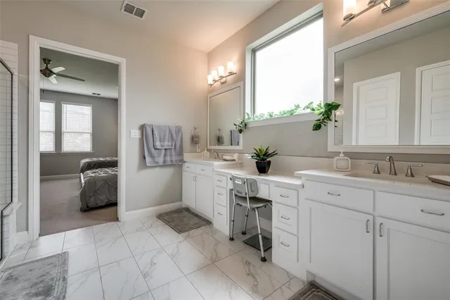 a en suite bathroom with a double vanity sink a mirror and a