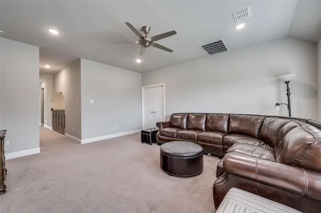 a living room with furniture a ceiling fan and a rug