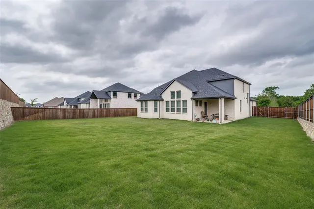a view of a house with a big yard potted plants and large tree