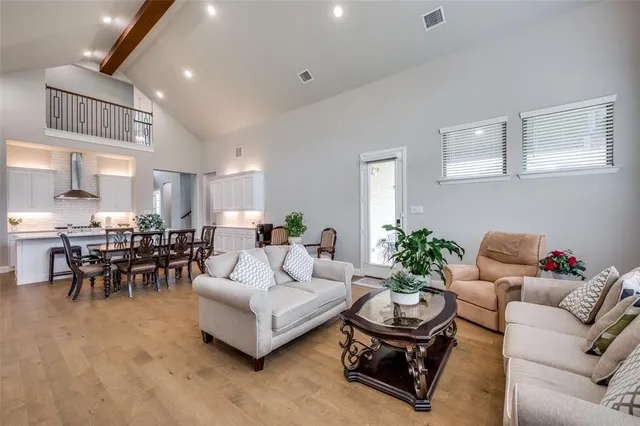a living room with furniture and a dining table with kitchen view