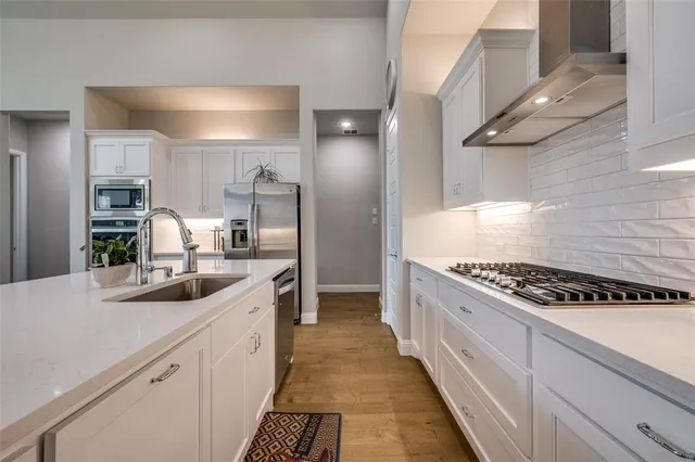 a kitchen with kitchen island stainless steel appliances a sink stove top oven and cabinets