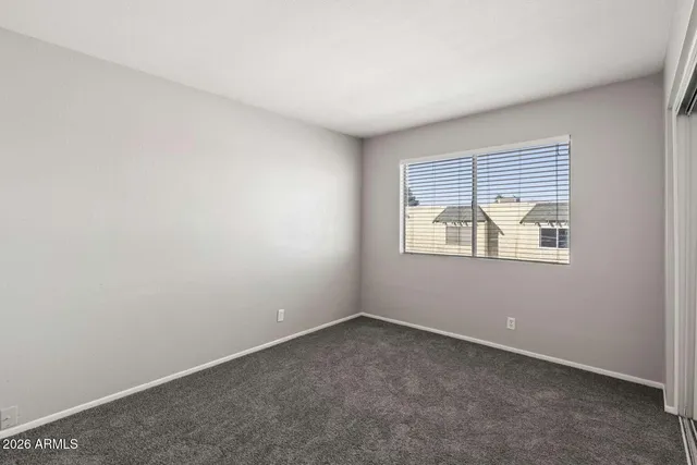 an empty room with closet and a bathroom