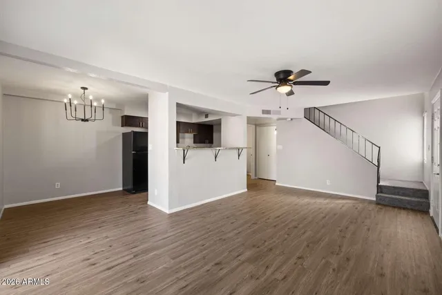a view of empty room with wooden floor and ceiling fan
