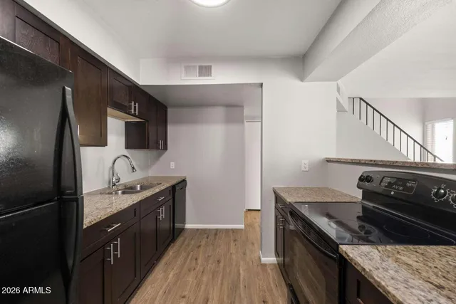 a kitchen with stainless steel appliances granite countertop a sink refrigerator and microwave