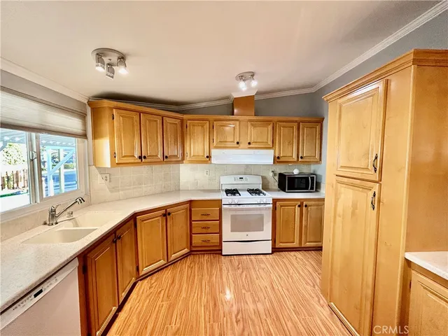 a kitchen with stainless steel appliances granite countertop a refrigerator a stove and a sink with cabinets