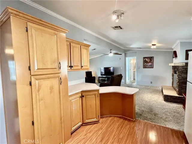 a kitchen with stainless steel appliances granite countertop a stove a sink dishwasher and a refrigerator with wooden floor