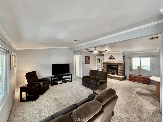 a living room with furniture a fireplace and a flat screen tv