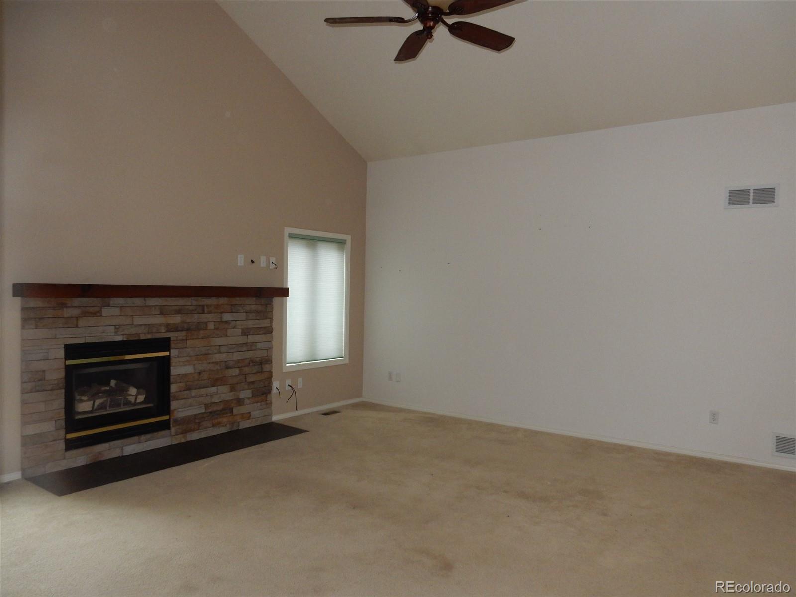 4324 Quail Street Wheat Ridge, CO 80033 - Photo 11 of 30 a view of a livingroom with a fireplace and a window