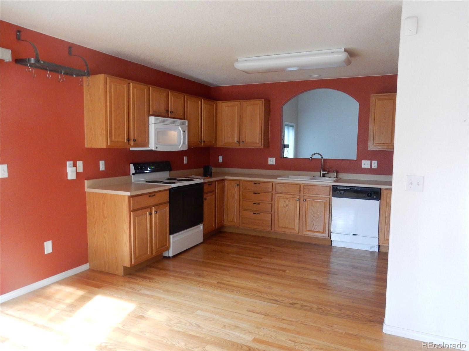 4324 Quail Street Wheat Ridge, CO 80033 - Photo 5 of 30 a kitchen with stainless steel appliances granite countertop a stove a sink and a microwave
