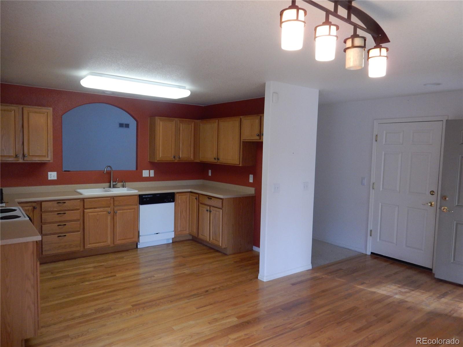 4324 Quail Street Wheat Ridge, CO 80033 - Photo 6 of 30 a kitchen with granite countertop a stove cabinets and wooden floor