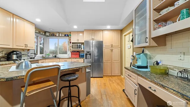 a kitchen with refrigerator a sink and wooden cabinets