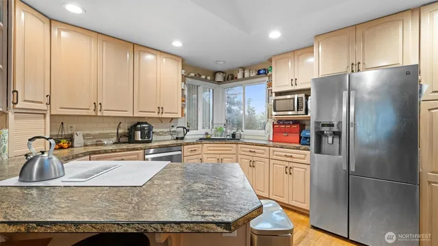 a kitchen with stainless steel appliances granite countertop a refrigerator sink and cabinets