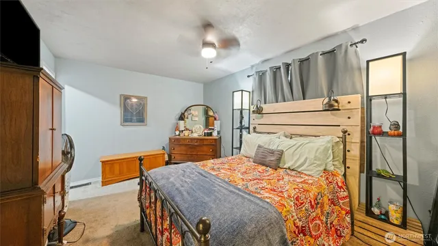 a bedroom with a bed and a flat tv screen on the dresser
