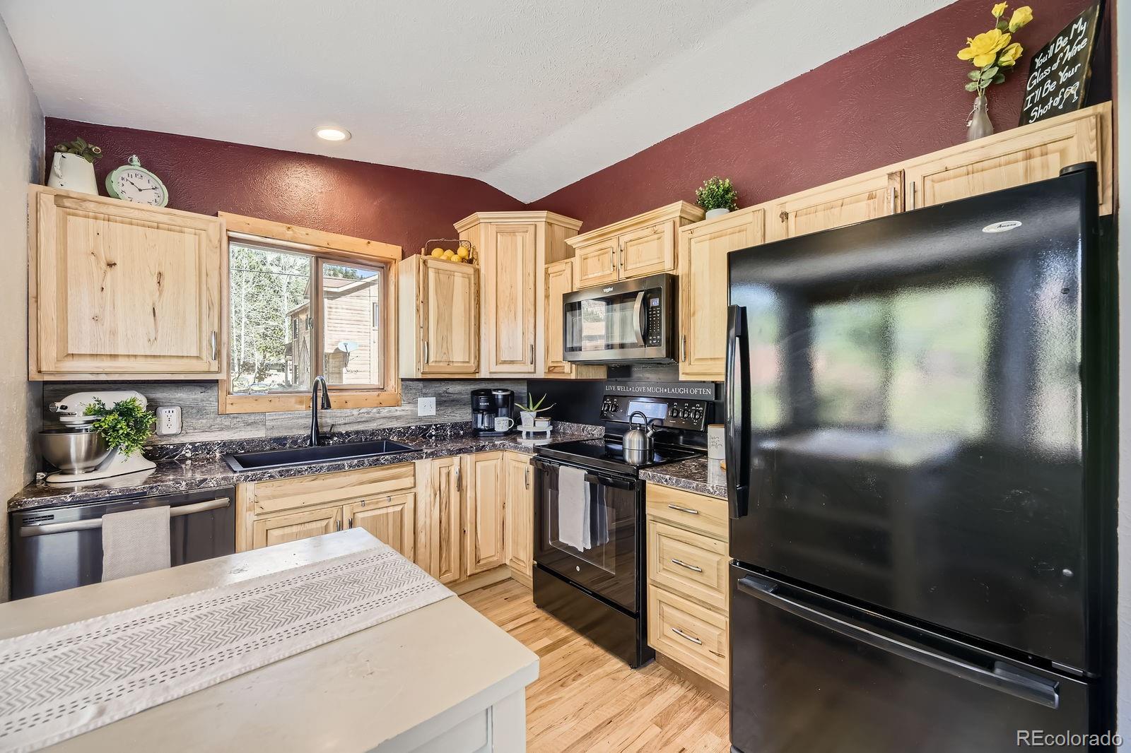 49 Silver Springs Road Bailey, CO 80421 - Photo 11 of 34 a kitchen with stainless steel appliances granite countertop a sink a stove and cabinets