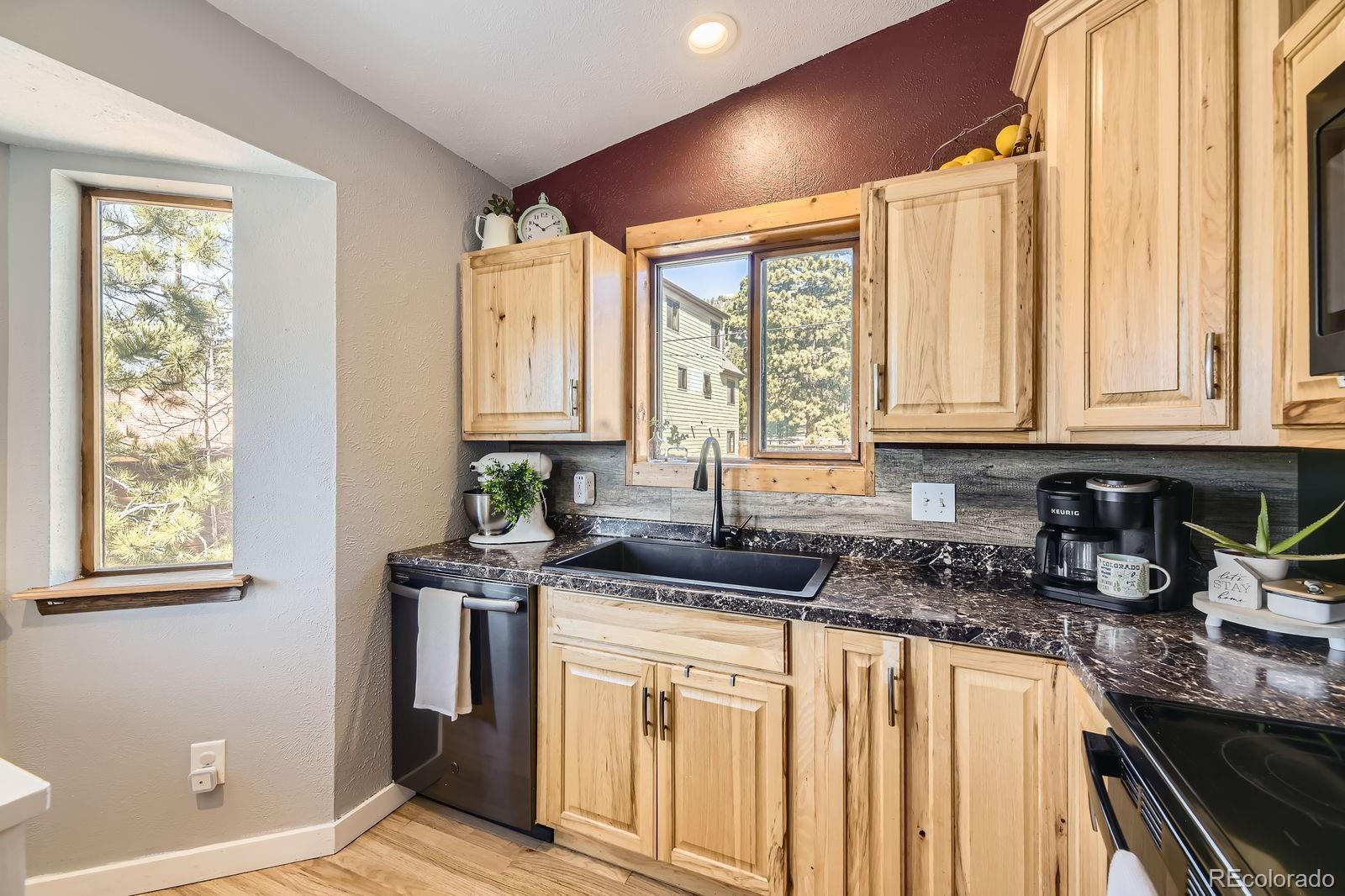 49 Silver Springs Road Bailey, CO 80421 - Photo 12 of 34 a kitchen with stainless steel appliances granite countertop a sink a stove and cabinets