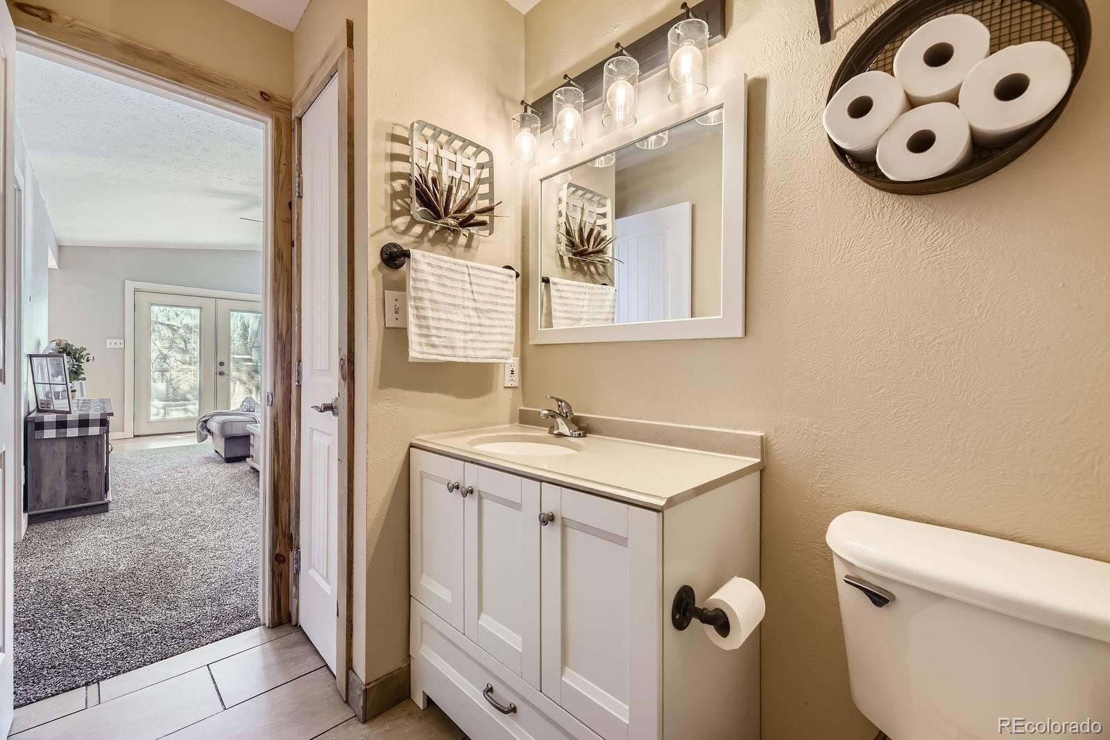 49 Silver Springs Road Bailey, CO 80421 - Photo 17 of 34 a bathroom with a sink a toilet and a mirror
