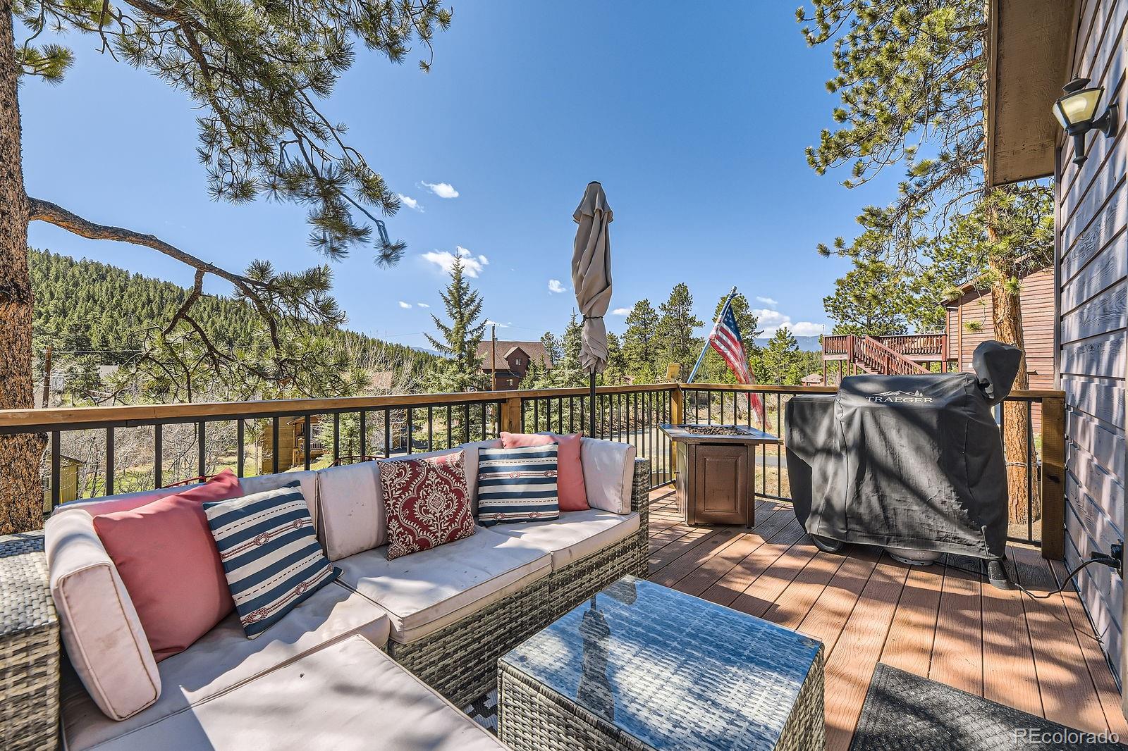 49 Silver Springs Road Bailey, CO 80421 - Photo 2 of 34 a view of a balcony with wooden floor and outdoor seating