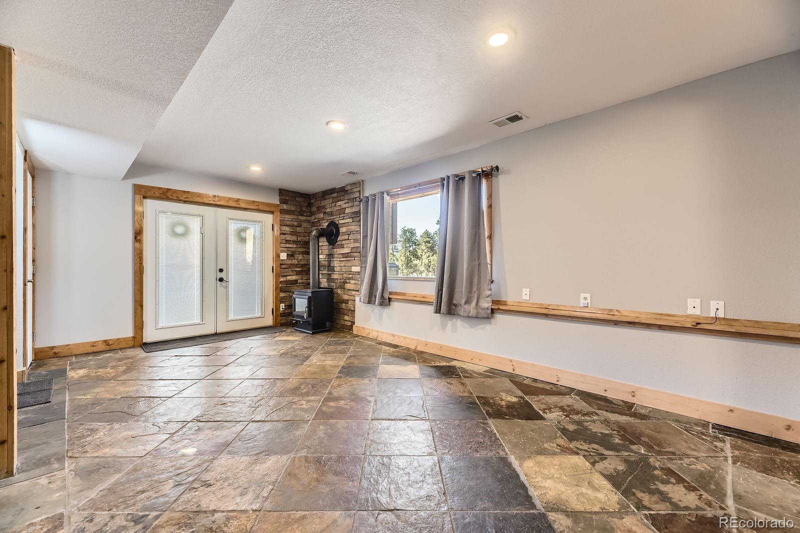 49 Silver Springs Road Bailey, CO 80421 - Photo 25 of 34 a view of an empty room with window and chandelier